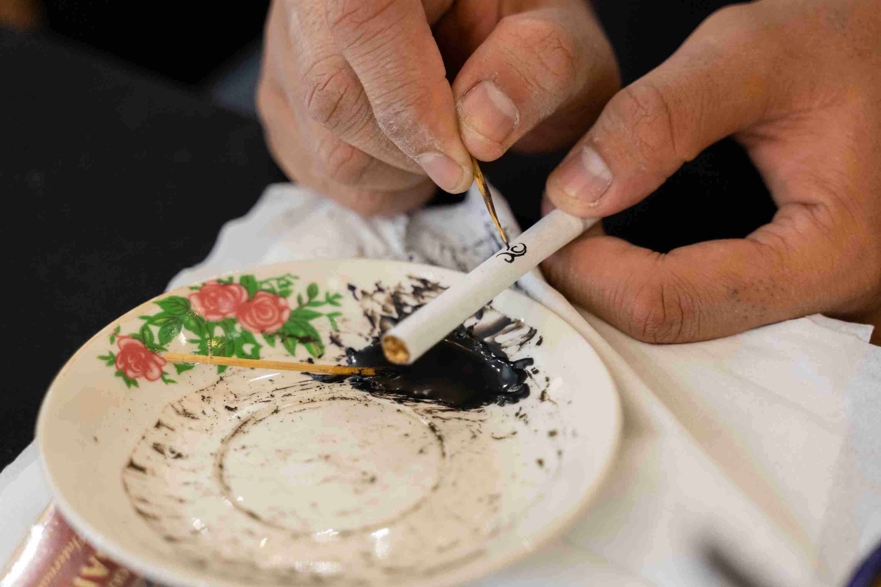 ('Nyete' merupakan sebuah tradisi lampau melukis batang rokok dengan ampas kopi. Foto: Dok. Jakarta Coffee Week)