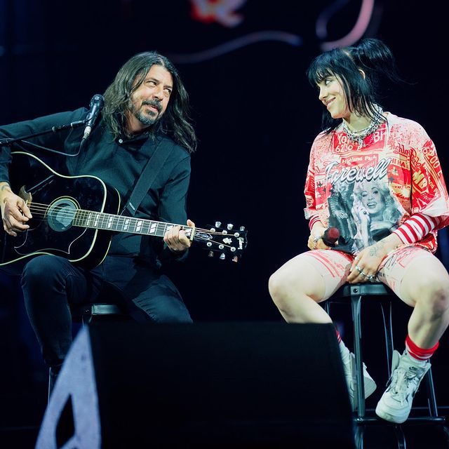 Billie menggunakan oversized t-shirt saat sedang konser